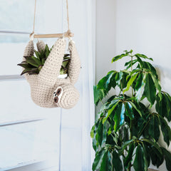 Evbopa sloth hanger holding a potted plant in a living room adding vertical greenery
