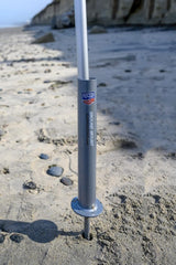 Flagpole‑To‑Go installed in sand marking a beach spot for quick visibility