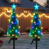 Lontl front view of two solar Christmas trees glowing, bright pathway accent