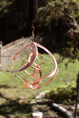 RCS Gifts Cosmix hanging in a garden adding kinetic sculpture to outdoor space
