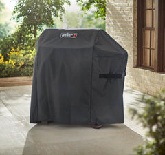 Weber cover next to patio chair showing scale and easy storage benefit