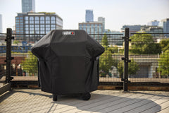 Weber cover on grill beside table showing fit and scale benefit