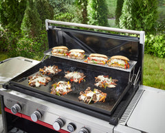 Weber warming rack in use toasting buns while freeing main griddle for searing