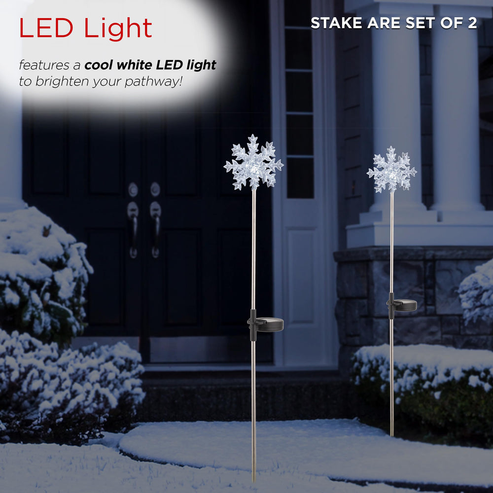 Alpine Corporation snowflake stakes lit in garden at night creating welcoming glow