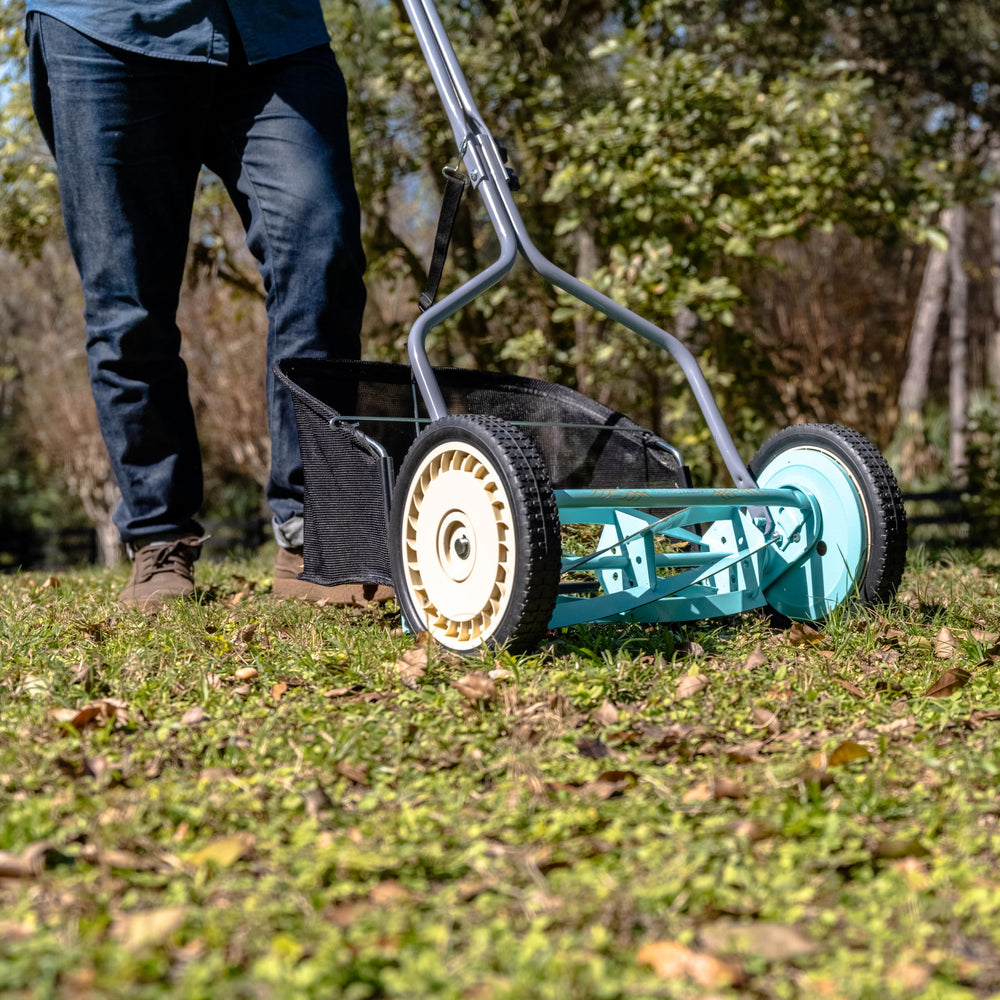 American Lawn Mower next to a garden hose for scale showing compact storage benefits