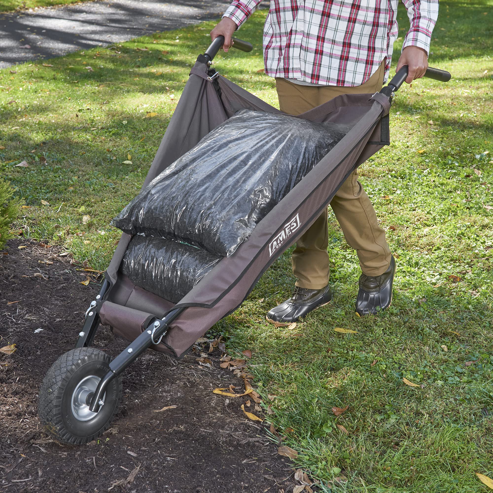 AMES wheelbarrow in a landscaped yard carrying soil and tools for efficient hauling