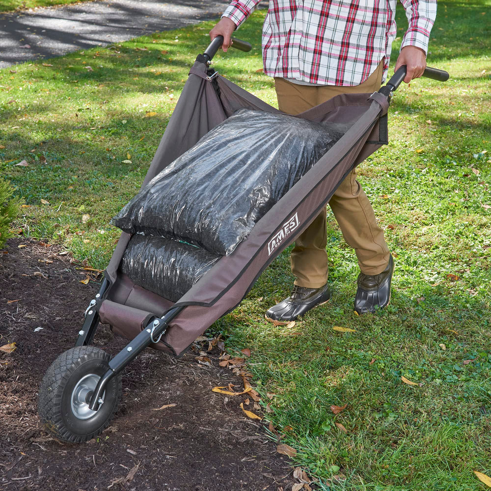 AMES wheelbarrow in a landscaped yard carrying soil and tools for efficient hauling