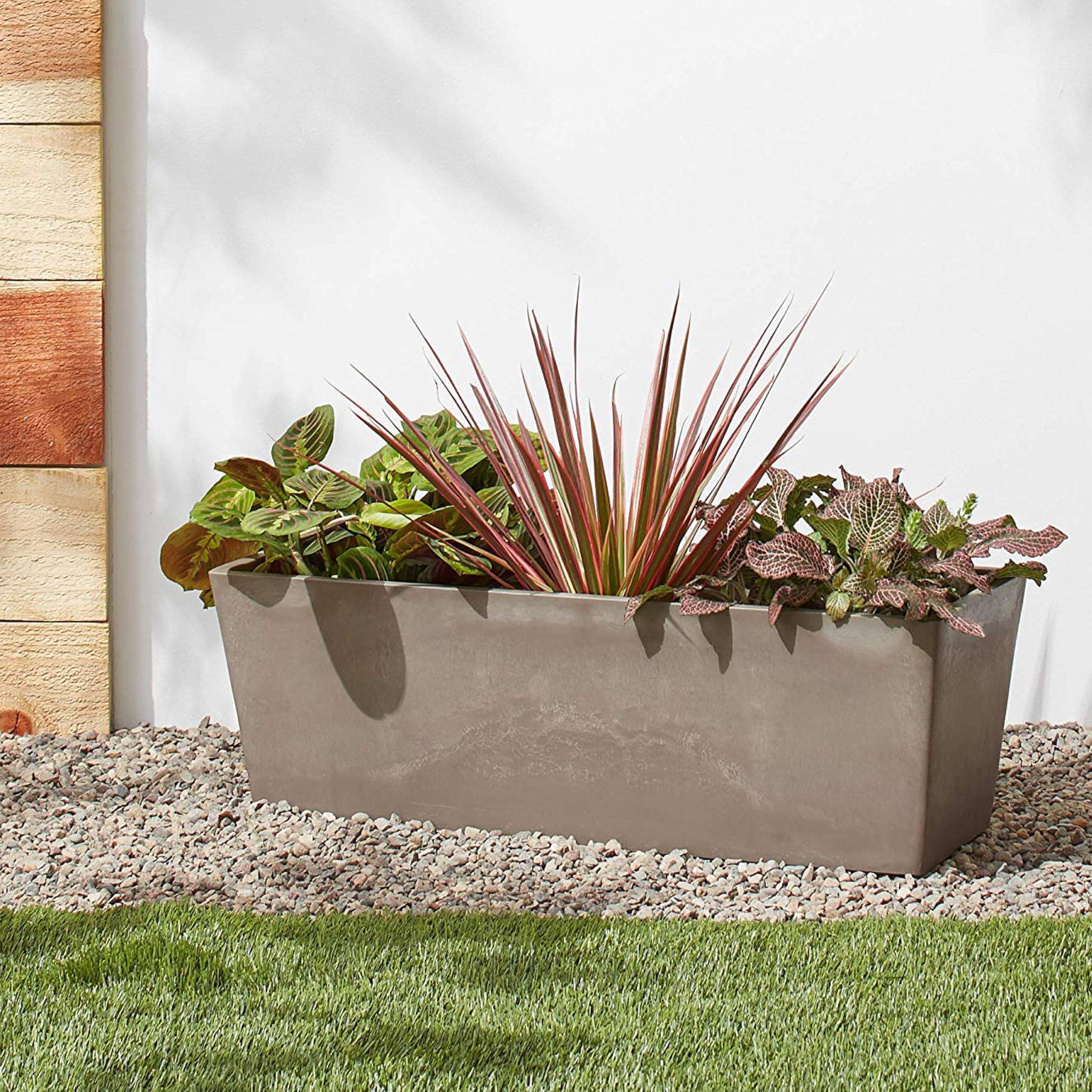 Arcadia Garden Products planted on a patio with flowers showing vibrant display and weather resistance