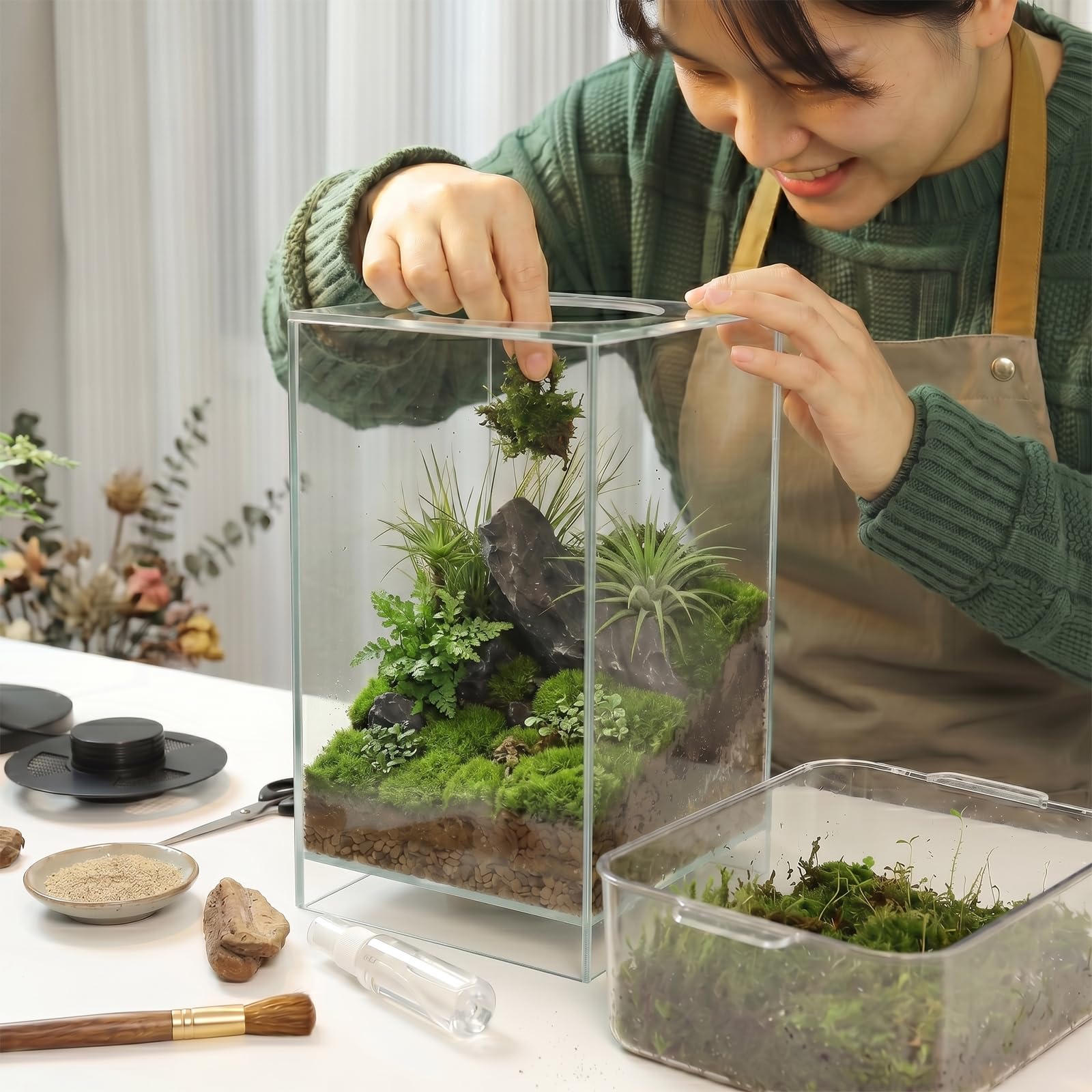 AREPK terrarium next to hand for scale showing compact desktop suitability