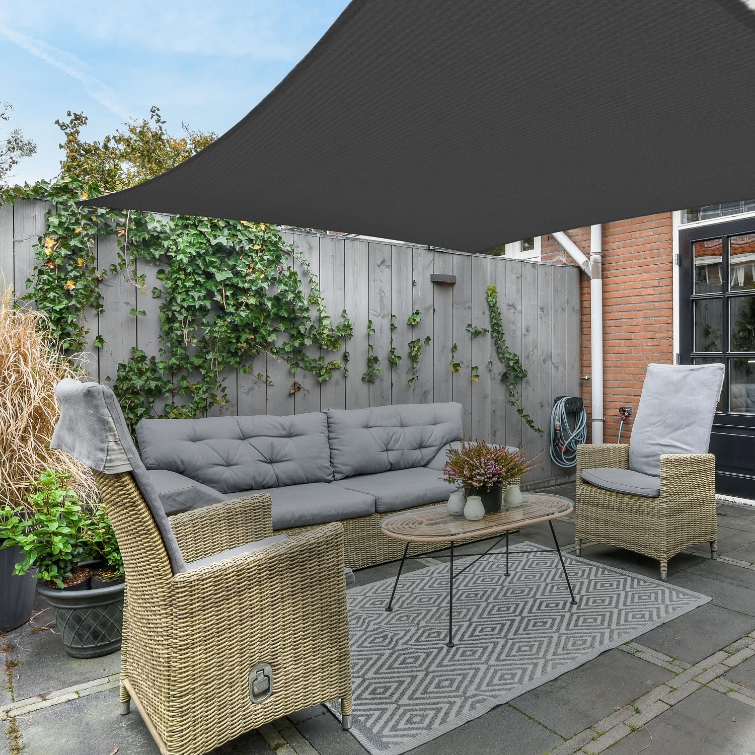 AsterOutdoor 10x10 sail next to a chair showing size and usable shaded area