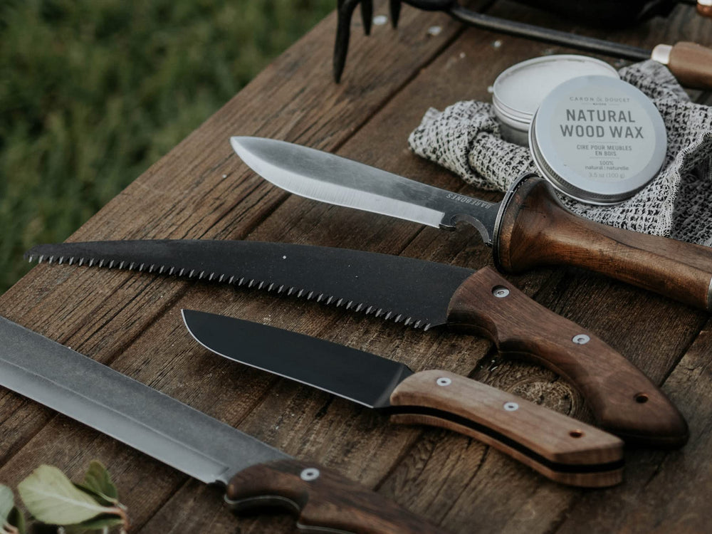 Barebones Timber Saw beside a hand and pack showing compact size and easy carry convenience