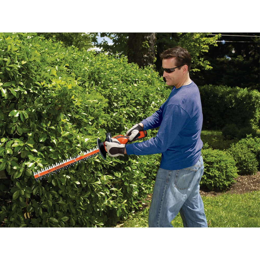 BLACK+DECKER size comparison next to a person showing 24-inch blade reach and yard coverage benefit