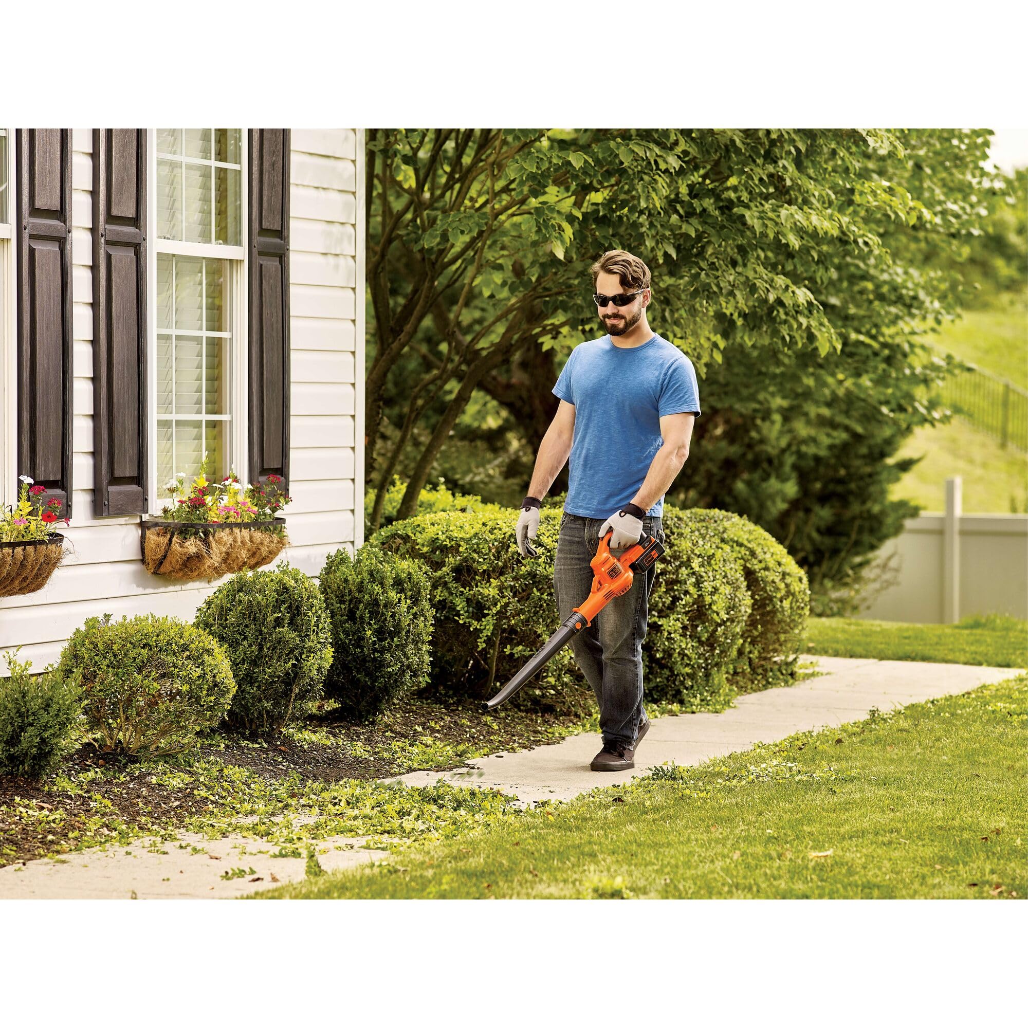BLACK+DECKER blower in use clearing leaves from a driveway for quick outdoor cleanup