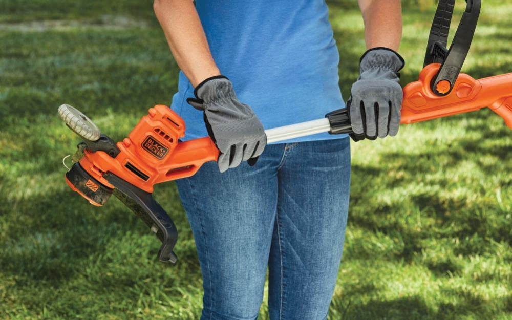 BLACK+DECKER BESTE620 in use trimming thick grass demonstrating effective cutting benefit