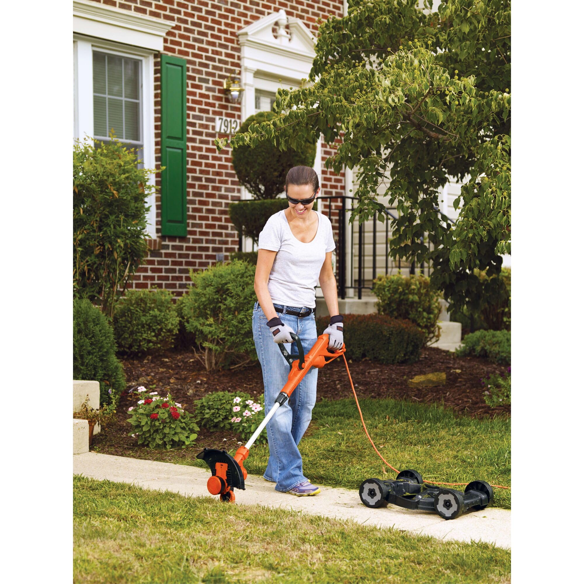 BLACK+DECKER beside measuring tape for scale showing 12-inch trimmer swath and size clarity