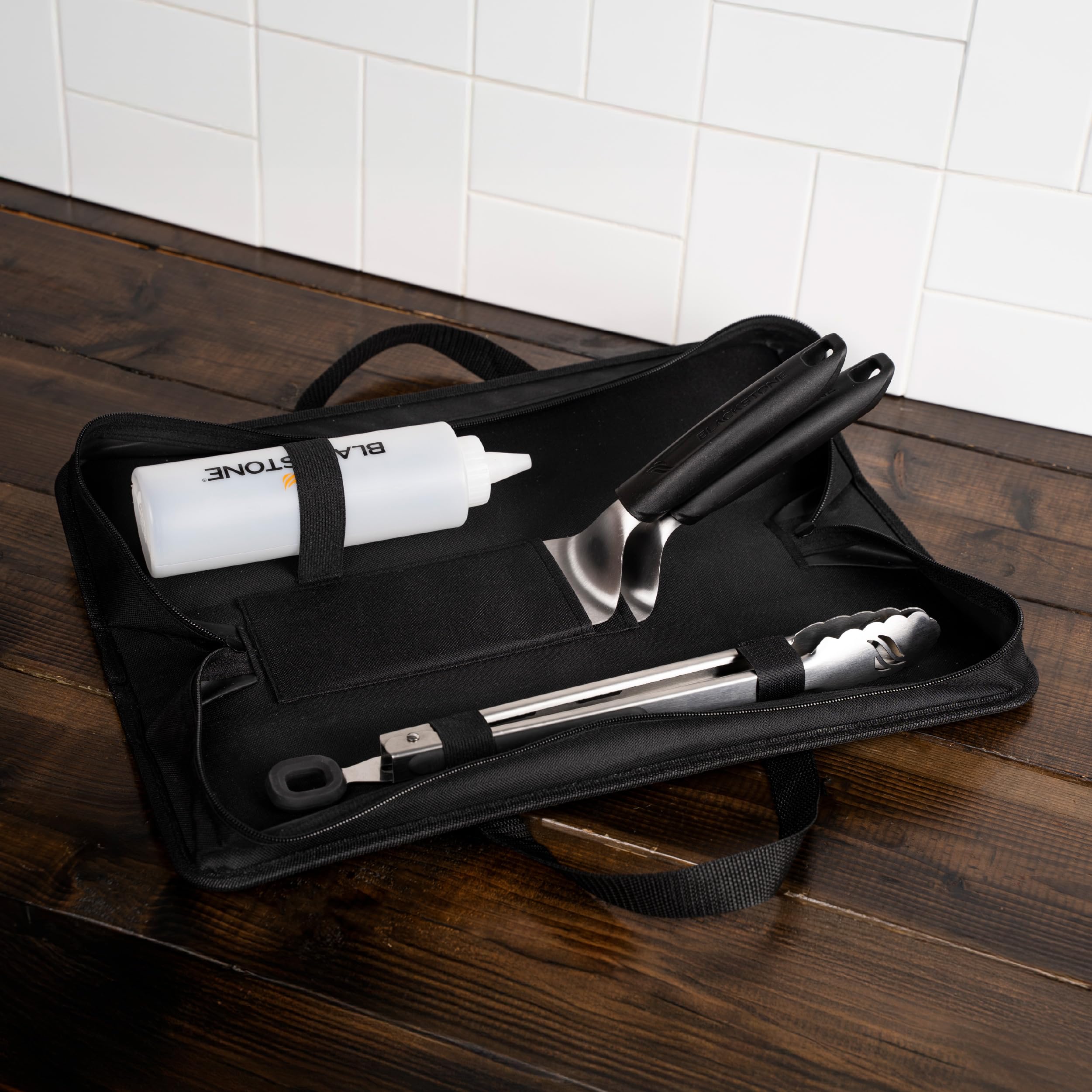 BLACKSTONE tongs in use on griddle turning food, offering secure grasp and safe handling