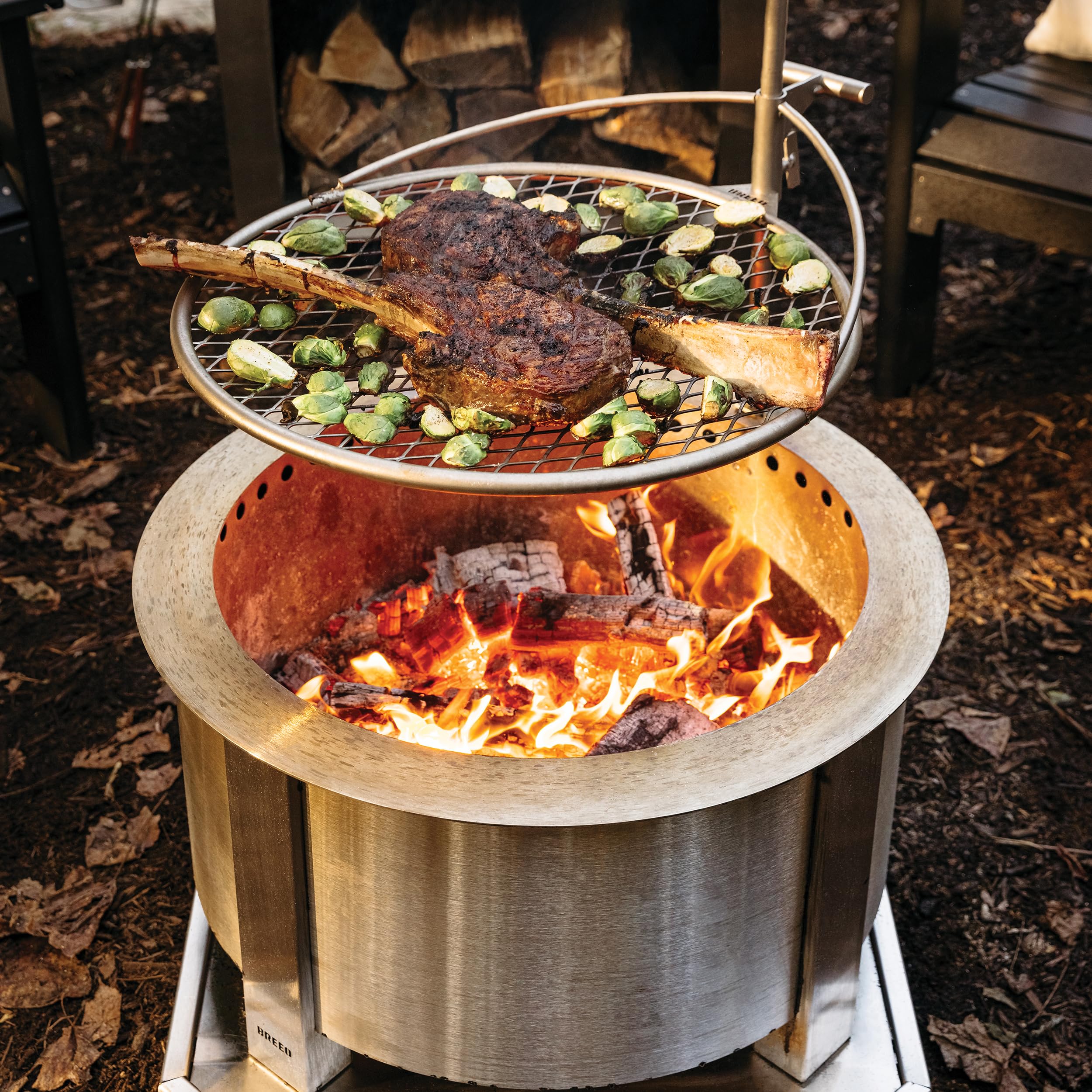 Breeo Outpost Grill 24 in campfire setting showing versatile outdoor cooking