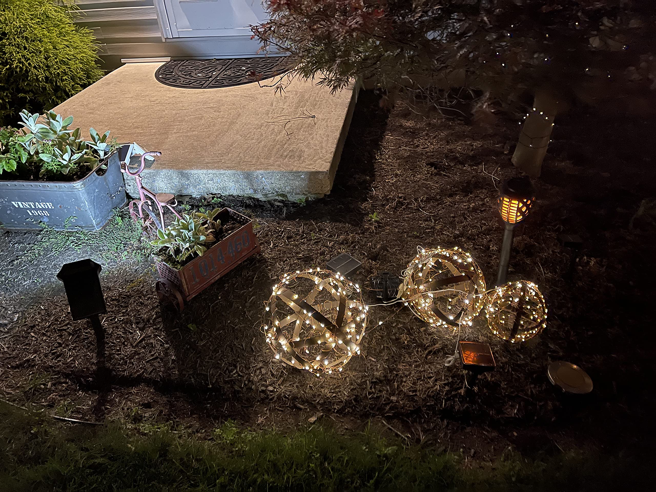 BSTGIFTS orbs lit by uplights casting patterned shadows to enhance evening ambiance