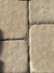 Worker sweeping BuddingCo sand into paver joints for easy installation and fast coverage
