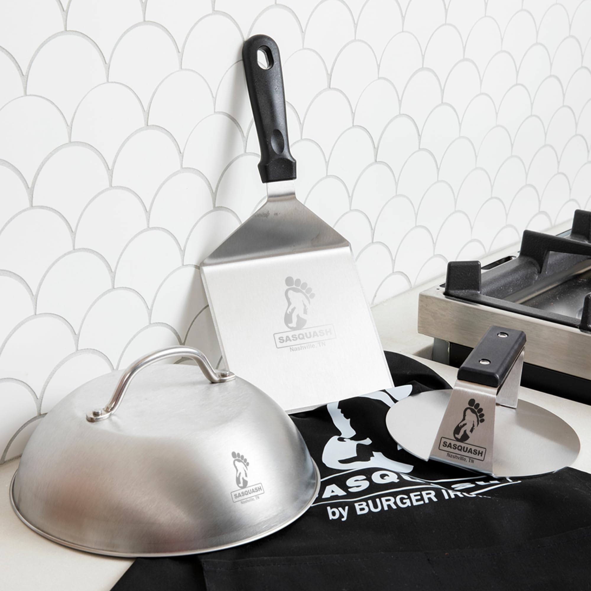 Burger Iron Sasquash beside a spatula and burger patty for scale and kitchen compatibility