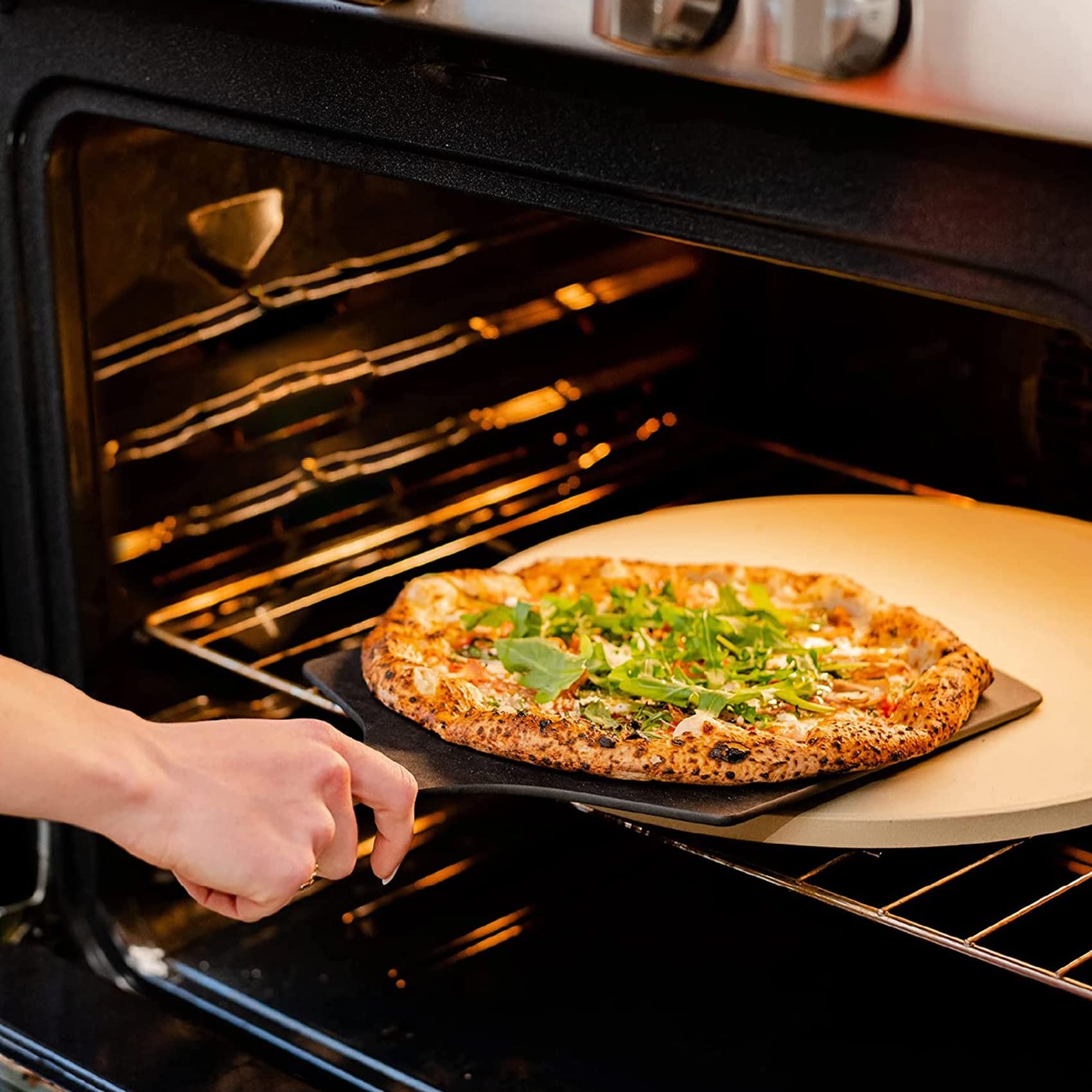 Burly Grill stone in oven with pizza cooking, demonstrating even browning and professional results
