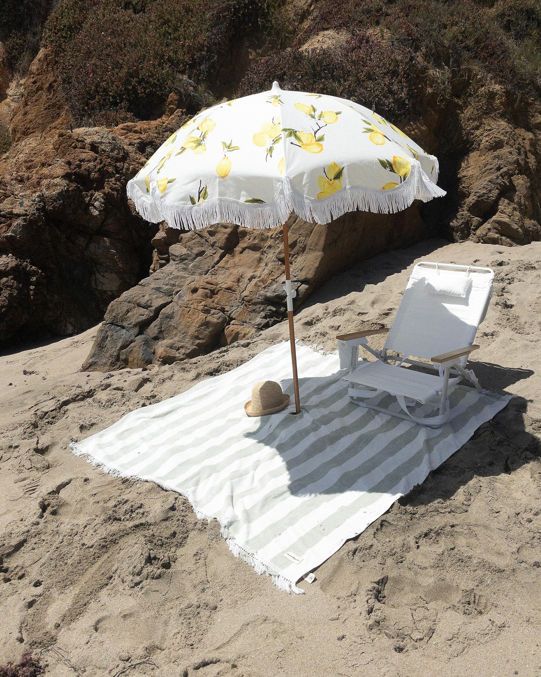 Business & Pleasure Co. umbrella in use on beach providing UPF 50+ shade for relaxation benefit