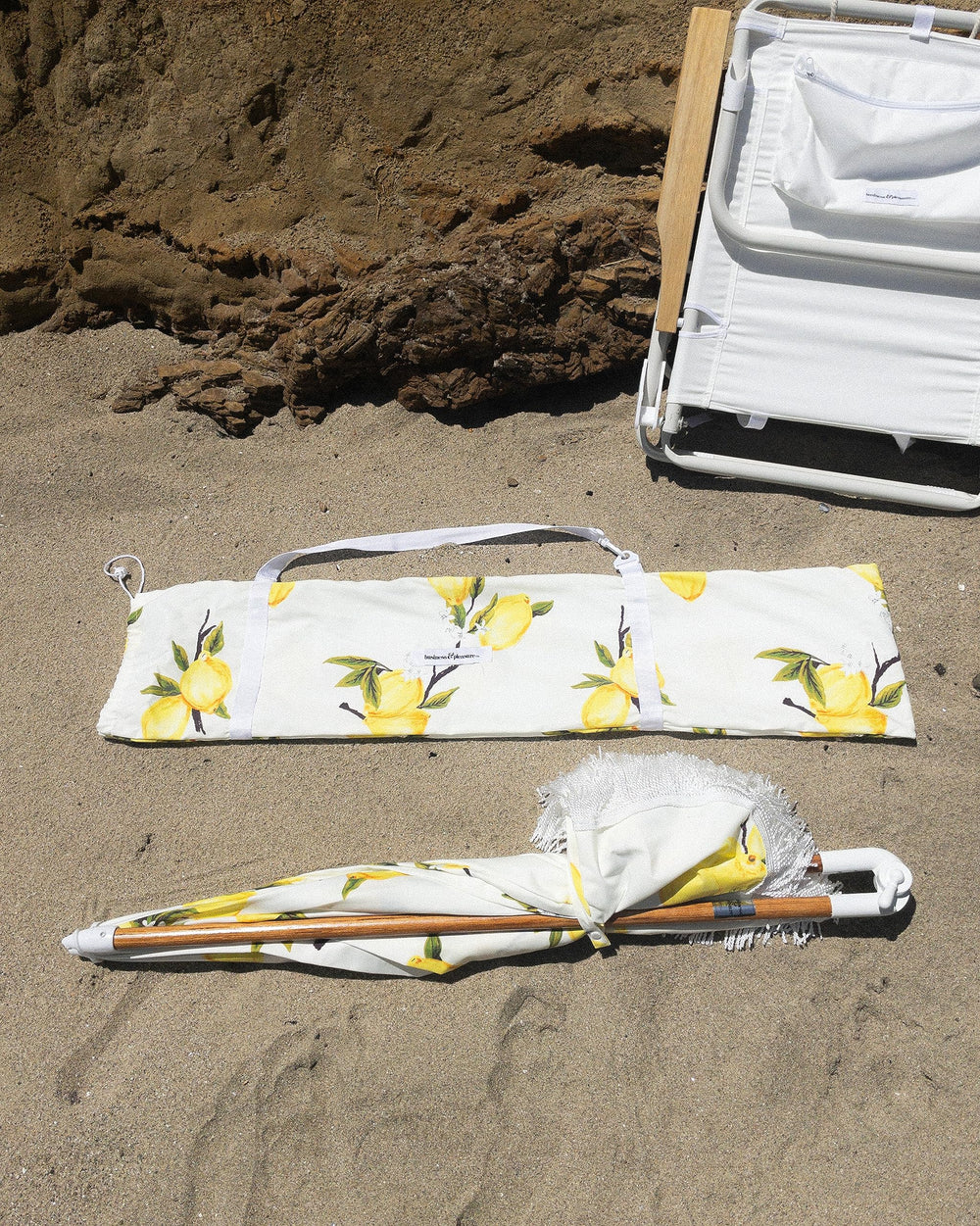 Business & Pleasure Co. umbrella next to chairs showing 5 by 6.5 foot coverage benefit