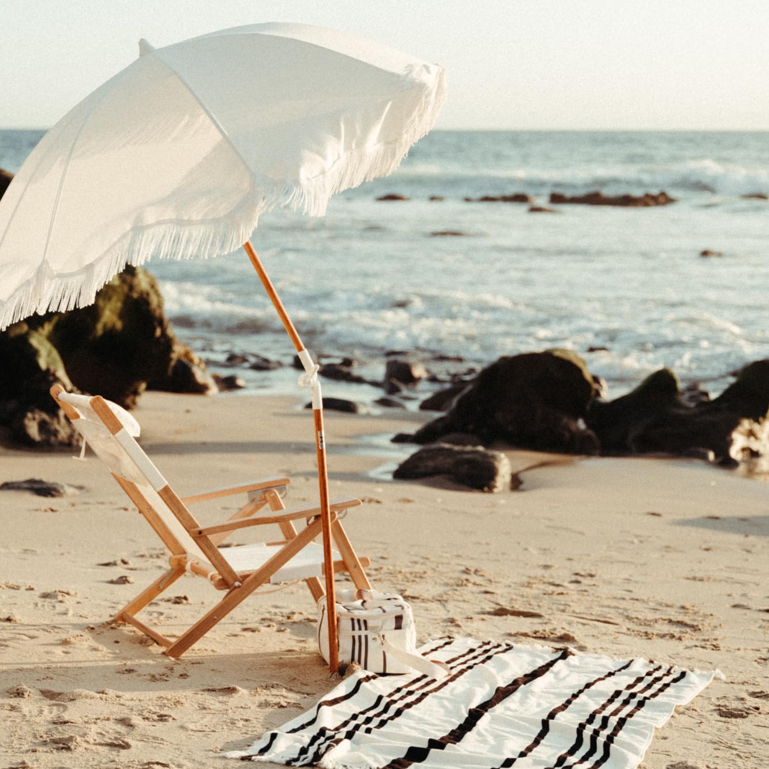 Business & Pleasure Co. umbrella next to beach chair showing coverage and practical scale