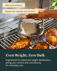 Caraway grill press on skillet pressing burger for faster, uniform browning
