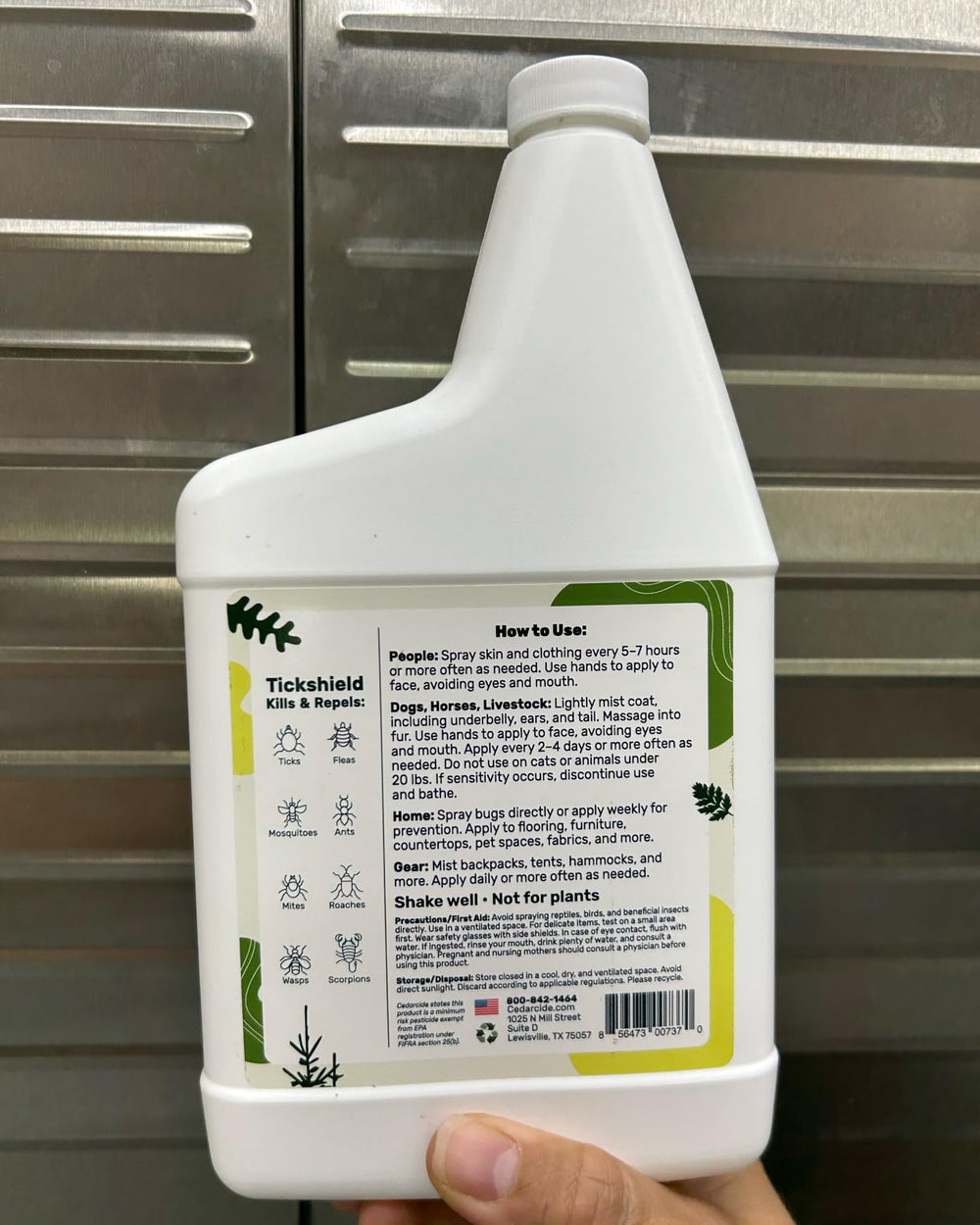 Cedarcide pint held next to hand to show pint size and easy household use