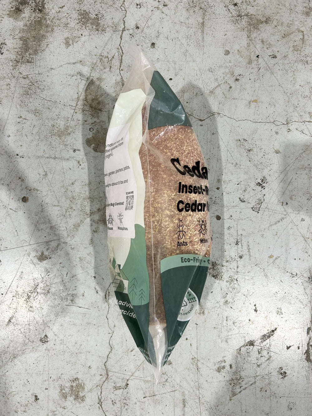Cedarcide granules beside a ruler demonstrating bag contents scale and coverage estimate