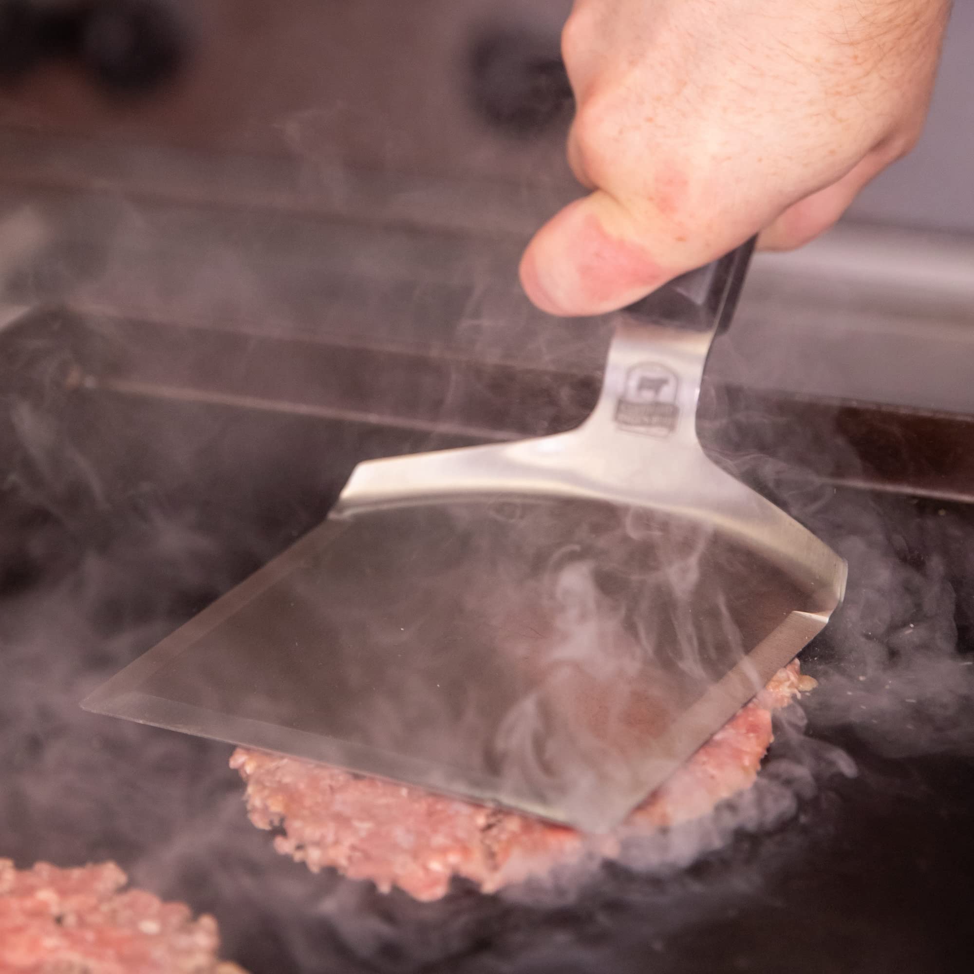Certified Angus Beef spatula stacking smashed burgers ready to serve with neat layers