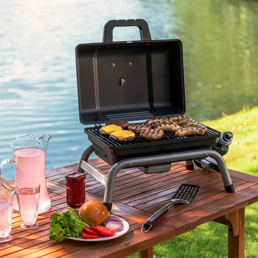 Charbroil compact grill next to 1-pound propane cylinder for scale convenience