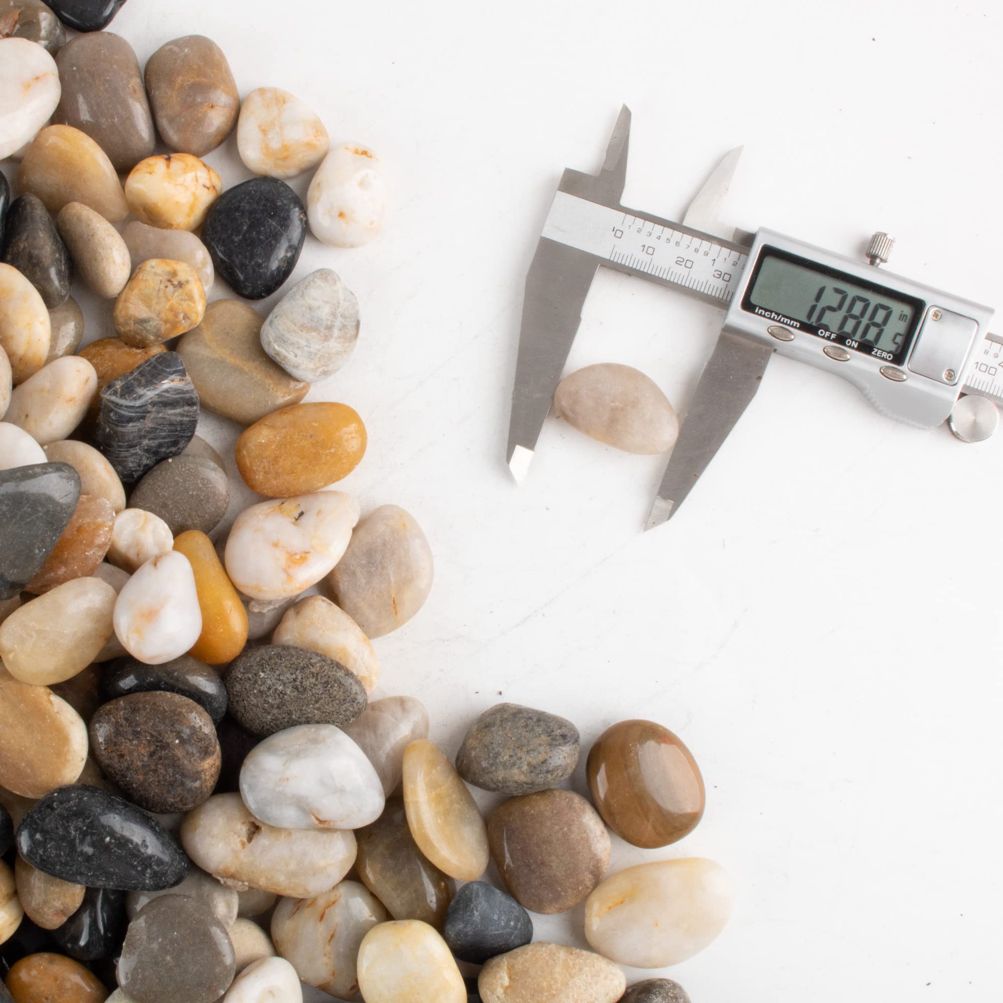 CJGQ hand holding pebble for scale illustrating 1–1.5 inch size and practical use