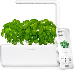 Click and Grow front view showing compact white smart garden and herbs growing, convenient counter use