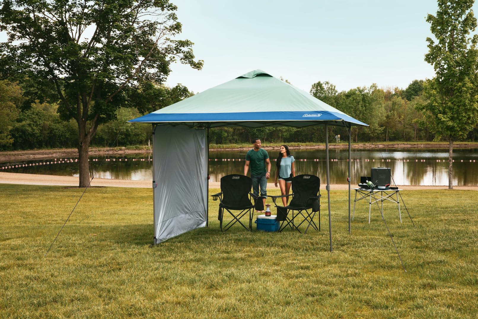 Coleman canopy set up in park providing shelter for outdoor gathering benefit