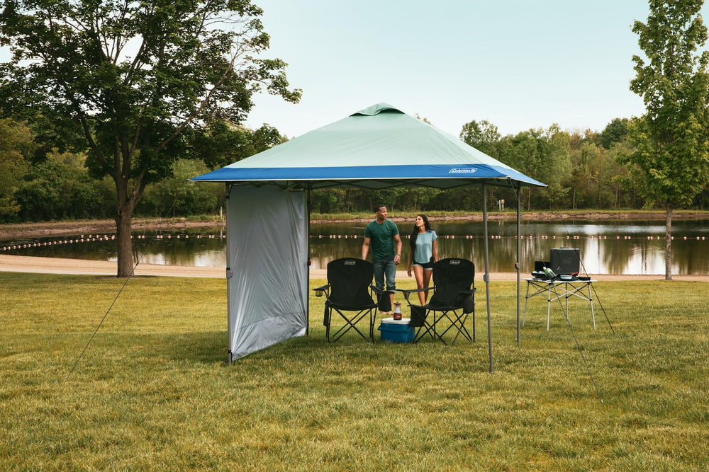 Coleman canopy set up in park providing shelter for outdoor gathering benefit