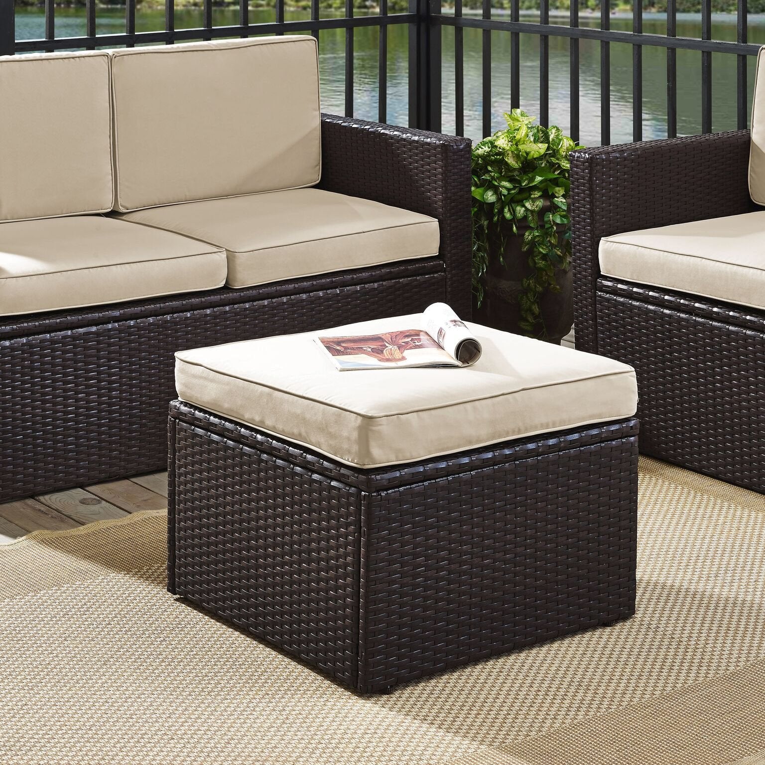 Crosley Palm Harbor ottoman used as footrest demonstrating outdoor relaxation