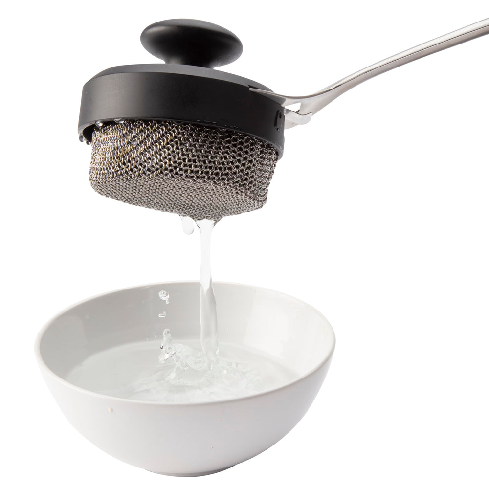 Cuisinart chainmail head cleaning a cast-iron skillet for versatile cookware use
