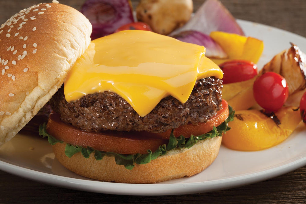Cuisinart melting dome in use on grill over burgers adding smoky flavor and quick melt