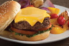Cuisinart melting dome in use on grill over burgers adding smoky flavor and quick melt