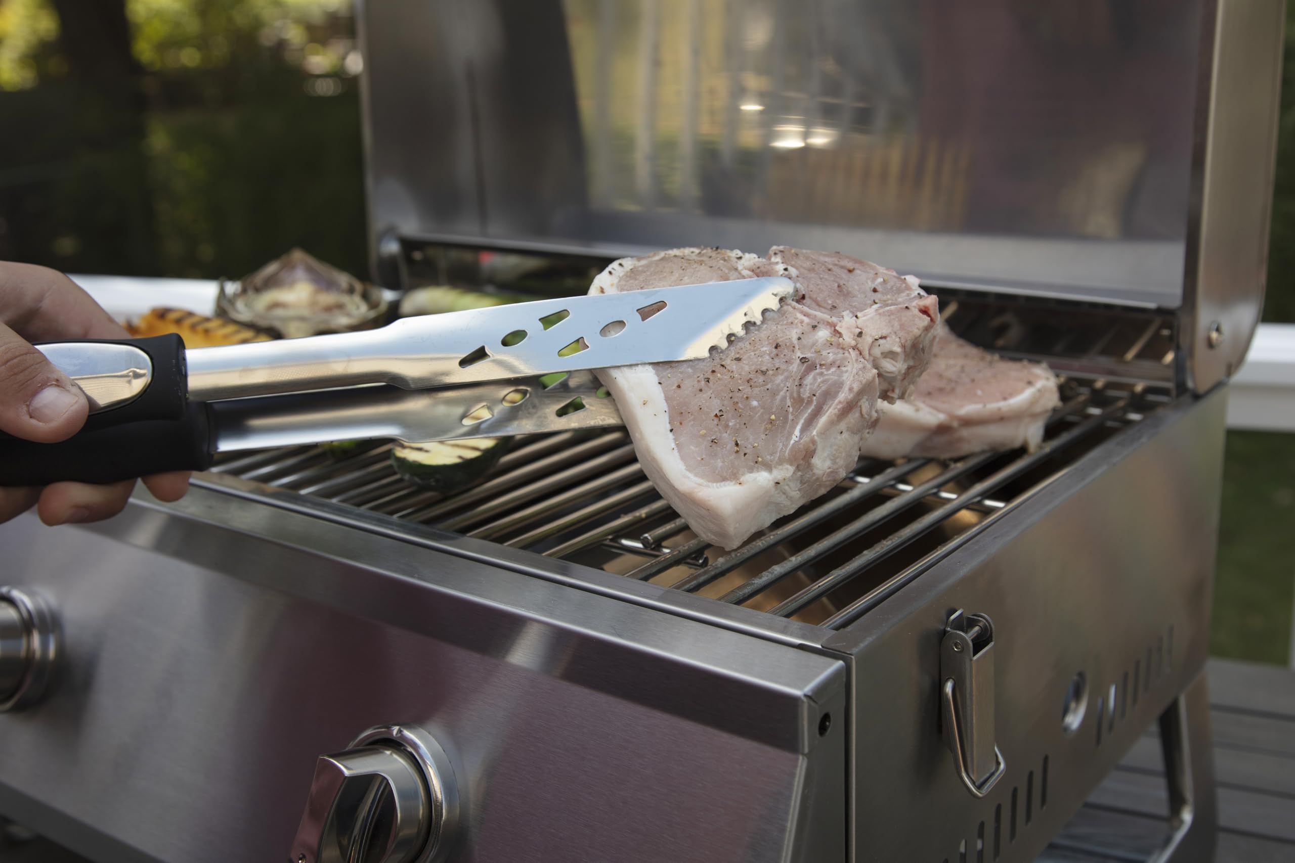 Cuisinart spatula and tongs turning burgers on a charcoal grill showing precise control