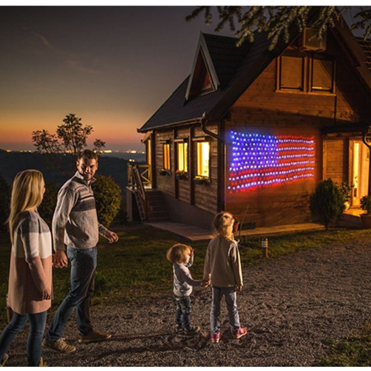 Decute nighttime yard display with flag lights creating bright holiday atmosphere