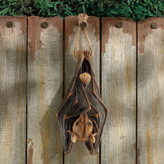 Design Toscano vampire bat hanging on porch creating dramatic Halloween ambiance