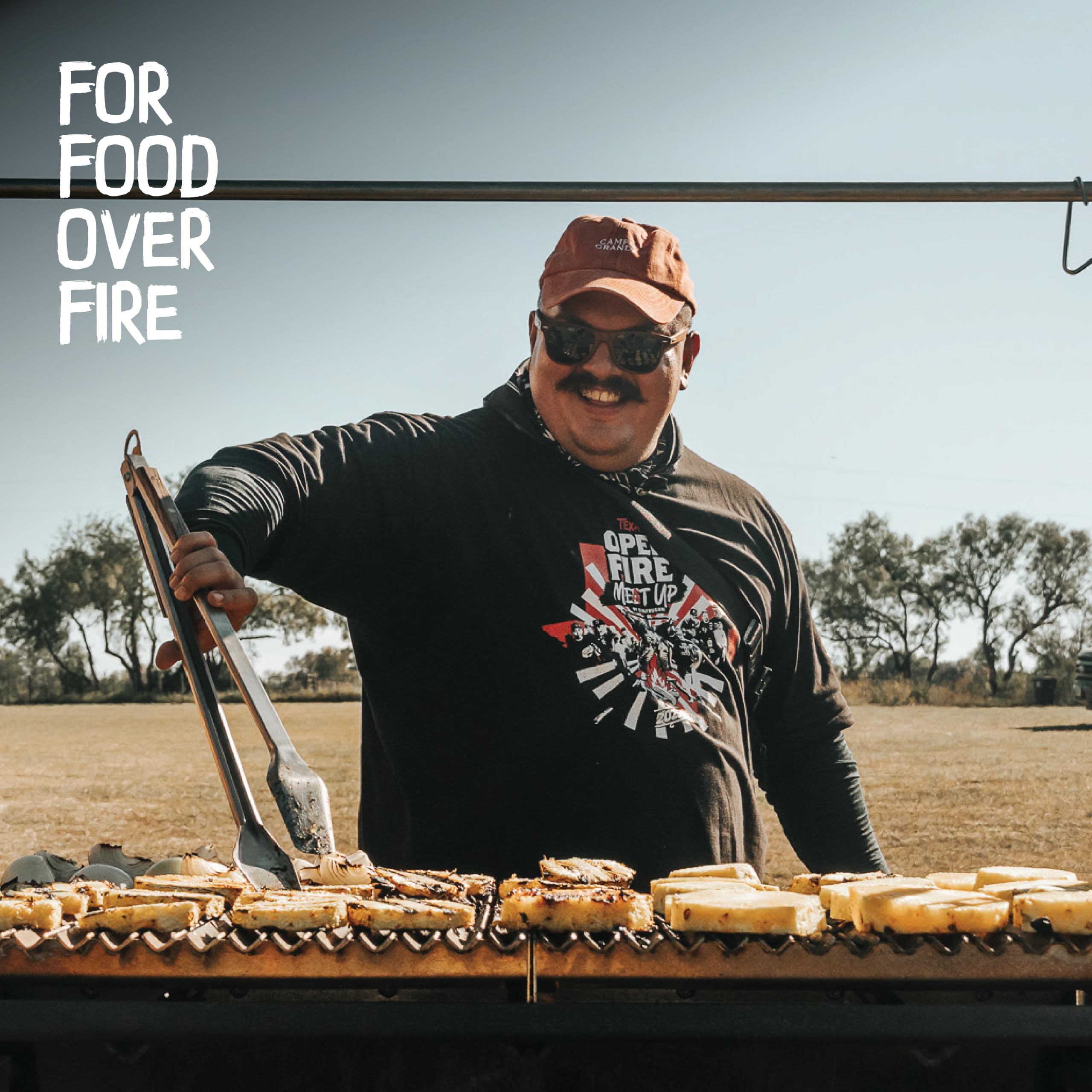 Donkey Long Tong in use flipping a steak on a grill giving precise control and distance from flames