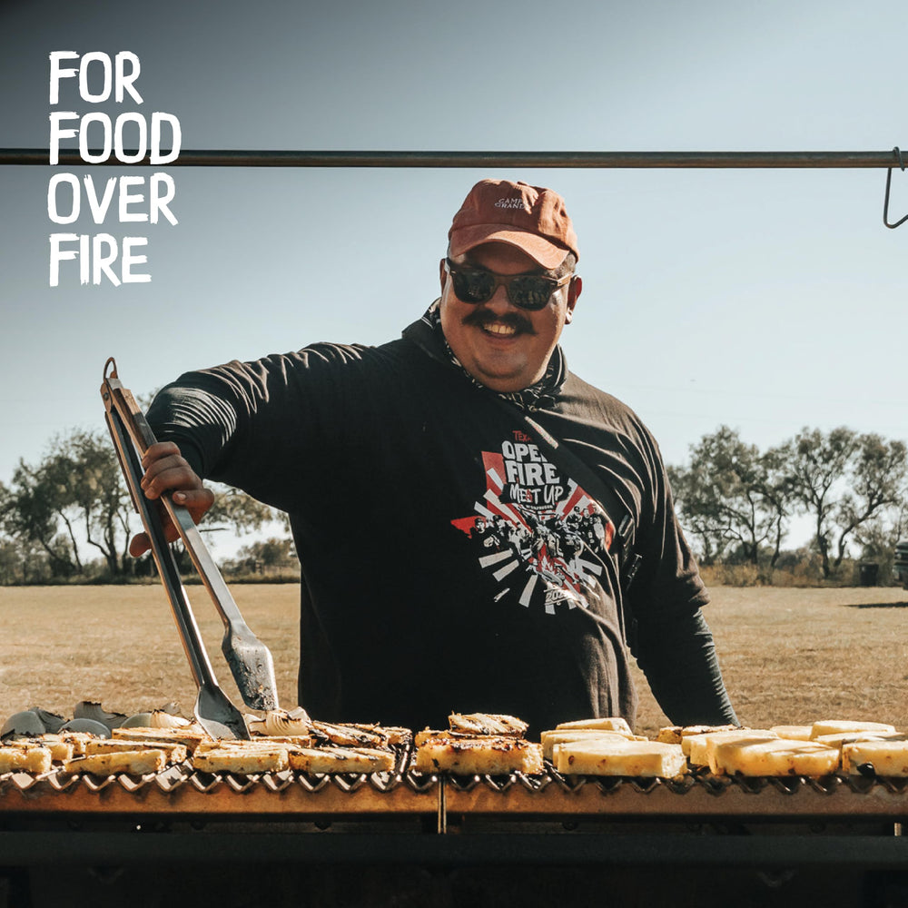 Donkey Long Tong in use flipping a steak on a grill giving precise control and distance from flames
