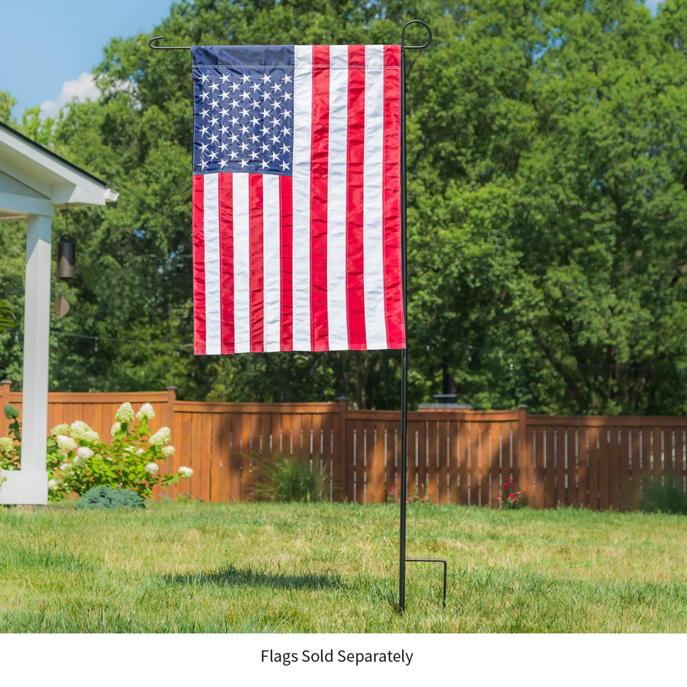 Evergreen stand on porch with seasonal flag enhancing curb appeal