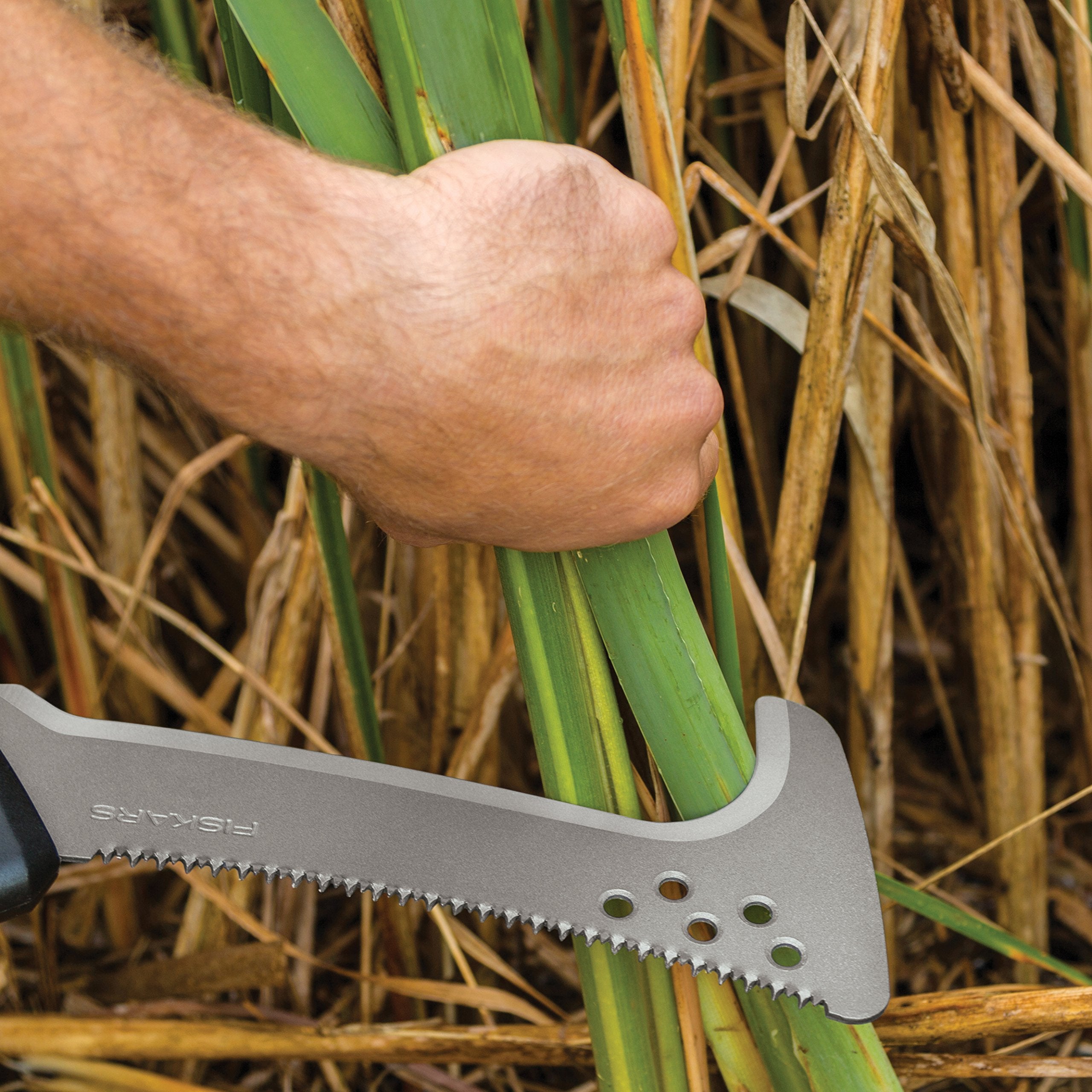 Fiskars saw beside a hand to show scale and easy one-handed operation