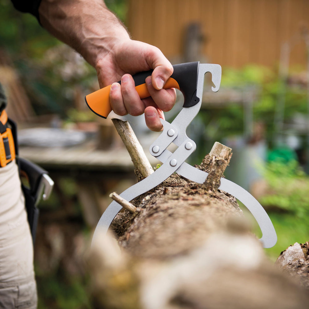 Fiskars tongs lifting a log one-handed demonstrating safer transport benefit