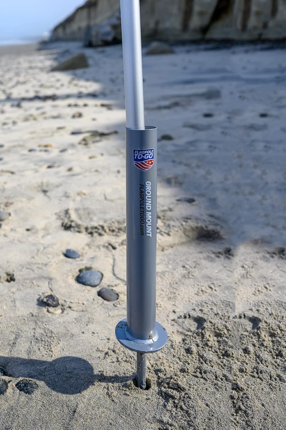 Flagpole‑To‑Go installed in sand marking a beach spot for quick visibility